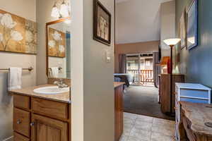 Bathroom with vanity, light carpet, and light tile patterned floors