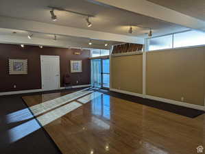 Interior space with dark wood-type flooring, track lighting, and expansive windows