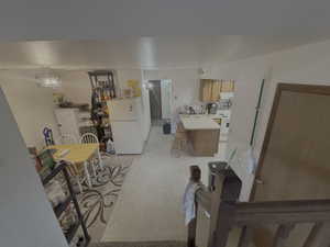 Kitchen featuring brown cabinets, a textured ceiling, white appliances, light countertops, and a peninsula