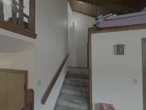 Stairway with wooden ceiling and lofted ceiling