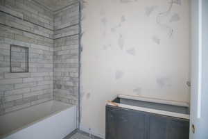 Bathroom featuring bathing tub / shower combination and baseboards