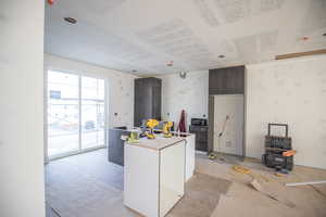 Kitchen with dark brown cabinets, modern cabinets, black microwave, and a kitchen island