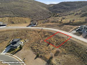 Aerial overview of property's location with property parcel outlined and a mountainous background