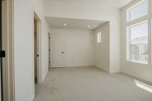 Unfurnished room with light colored carpet and recessed lighting