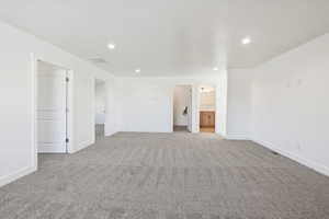 Unfurnished bedroom featuring recessed lighting, light colored carpet, and ensuite bathroom