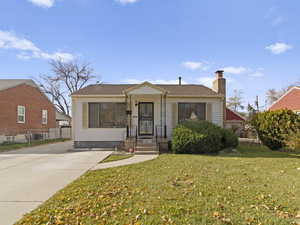 Bungalow-style house with a front yard, a chimney, and a shingled roof