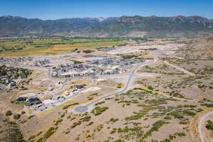 Aerial overview of property's location with a mountainous background and nearby suburban area