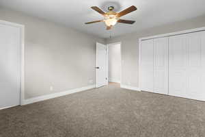 Unfurnished bedroom with carpet flooring, a ceiling fan, and a closet