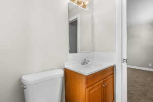 Half bath with vanity and carpet flooring