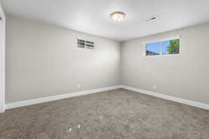 Carpeted empty room featuring baseboards