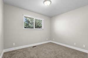 Empty room with carpet and baseboards