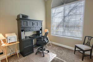 Office with baseboards and light carpet