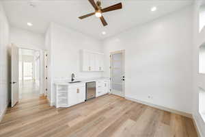 Bar area with white cabinets, open shelves, light countertops, a ceiling fan, and light wood-type flooring