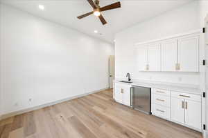 Bar featuring white cabinets, stainless steel refrigerator, light wood-style floors, recessed lighting, and a ceiling fan