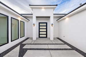 View of exterior entry with stucco siding