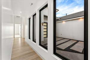 Hallway to casita featuring wood finished floors and recessed lighting