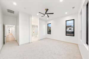 Unfurnished bedroom featuring light colored carpet, recessed lighting, ceiling fan, and ensuite bathroom