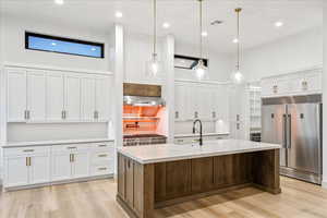 Kitchen featuring appliances with stainless steel finishes, white cabinets, light wood-type flooring, and recessed lighting