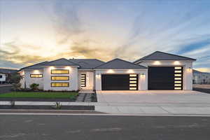 Contemporary home featuring an attached garage, driveway, and stucco siding