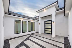 View of exterior entry featuring stucco siding and a tile roof