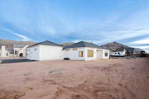 Rear view of property with a mountain view and stucco siding