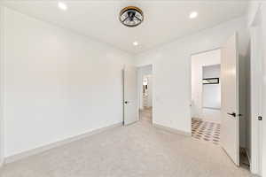 Unfurnished bedroom featuring light colored carpet and recessed lighting