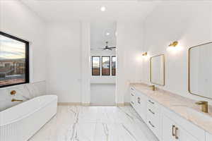 Full bath with a soaking tub, recessed lighting, double vanity, light marble finish floors, and ceiling fan