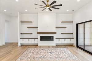 Unfurnished living room with recessed lighting, light wood-style floors, a glass covered fireplace, and ceiling fan
