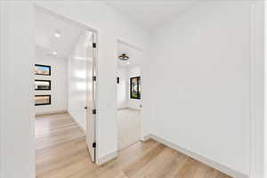 Corridor with light wood-style flooring and recessed lighting