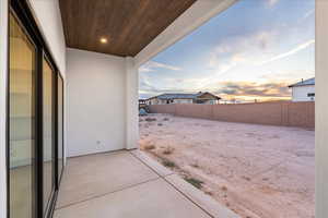 Partially fenced backyard featuring a patio