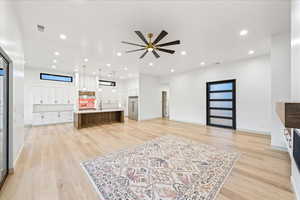 Living room featuring light wood-style floors, recessed lighting, and a ceiling fan