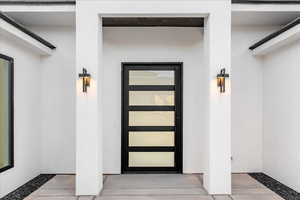 Main doorway to property with stucco siding