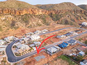 Aerial view of property and surrounding area featuring mountains and nearby suburban area