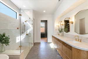 Full bath with double vanity, a stall shower, a bath, and recessed lighting