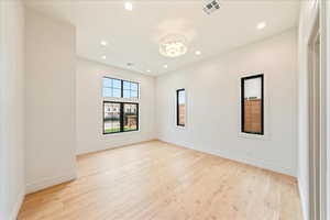 Empty room with light wood-style flooring and recessed lighting