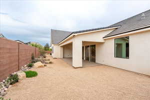 Rear view of property featuring a patio, stucco siding, and a tile roof