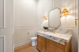 Bathroom featuring vanity, a decorative wall, and light wood-type flooring