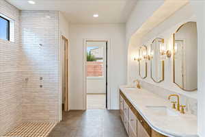 Full bath with double vanity, a tile shower, recessed lighting, and dark tile patterned floors