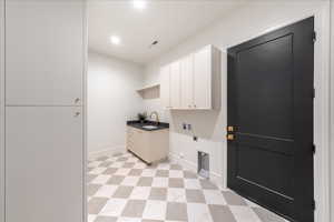 Laundry room featuring electric dryer hookup, cabinet space, hookup for a gas dryer, light floors, and washer hookup