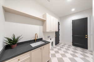 Laundry room with light floors, cabinet space, and hookup for a washing machine
