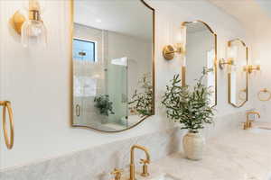 Full bath featuring a shower stall and double vanity