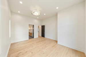 Unfurnished bedroom featuring light wood finished floors, recessed lighting, and ensuite bathroom