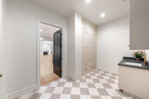 Laundry area with a fireplace, light flooring, and recessed lighting