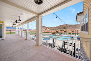 Fenced backyard featuring a community pool, a mountain view, and a patio area