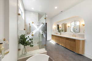 Bathroom featuring double vanity, a shower stall, a soaking tub, recessed lighting, and dark tile patterned flooring