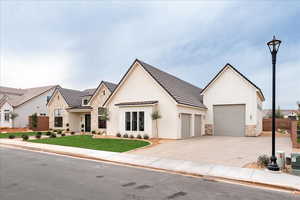 View of front of property featuring stone siding, a standing seam roof, a metal roof, and concrete driveway