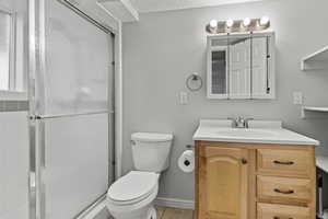 Full bath featuring vanity, a shower stall, and a textured ceiling