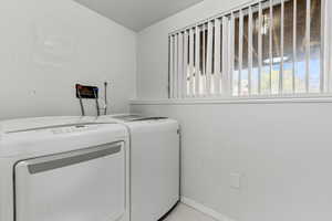 Laundry room featuring a textured ceiling and washer and clothes dryer