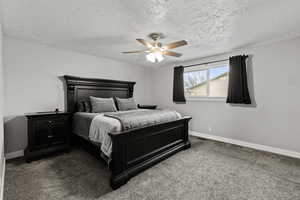 Bedroom with carpet flooring, a ceiling fan, and a textured ceiling