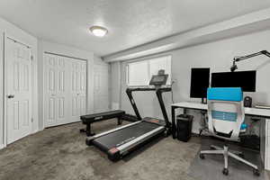 Workout area featuring a textured ceiling and carpet